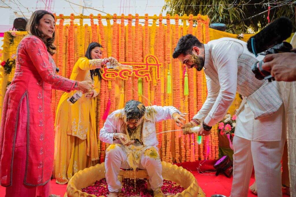 Friends having fun with groom during haldi ceremony