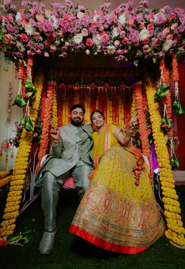 Happy bride in a yellow lehnga and groom in green shervani