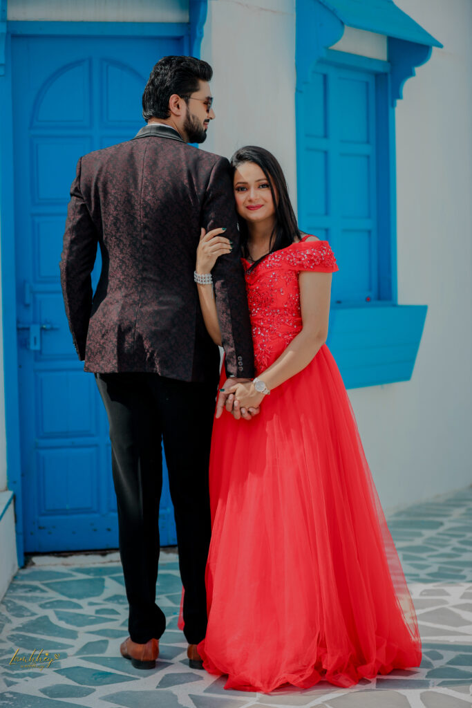 Boy in black tuxedo and girl in a red dress holding hands