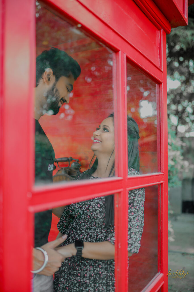 Closeup view of a boy and a girl in a red phone booth