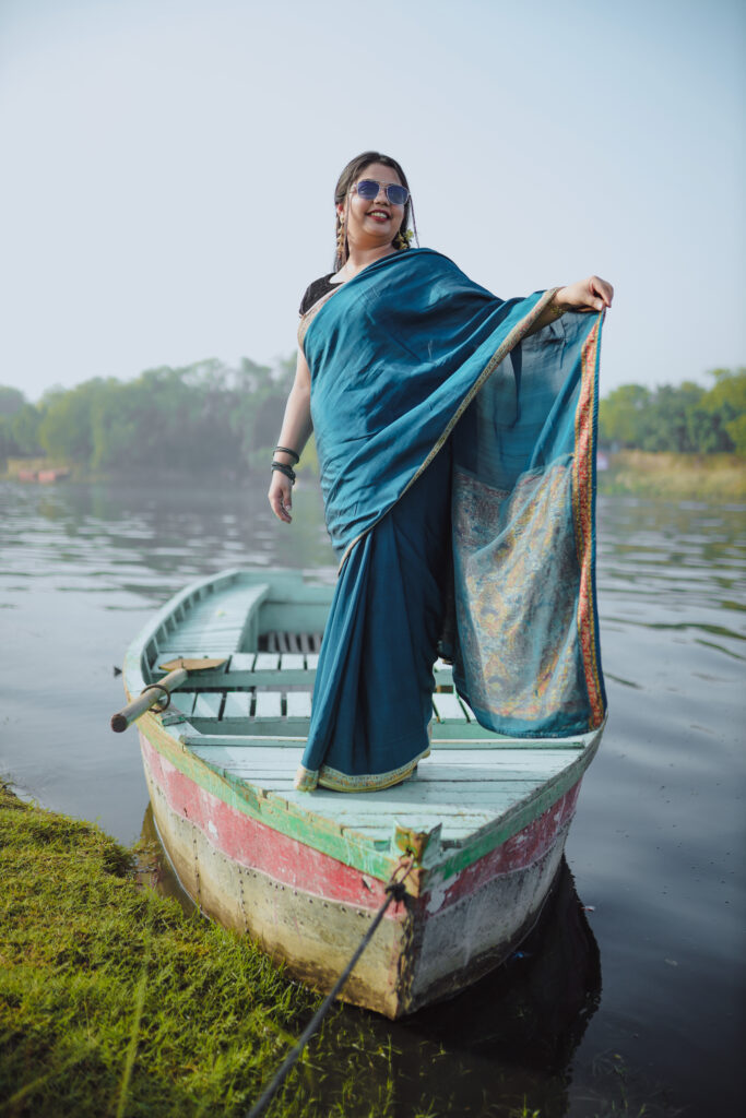 Girl in a blue saree posing on a boat