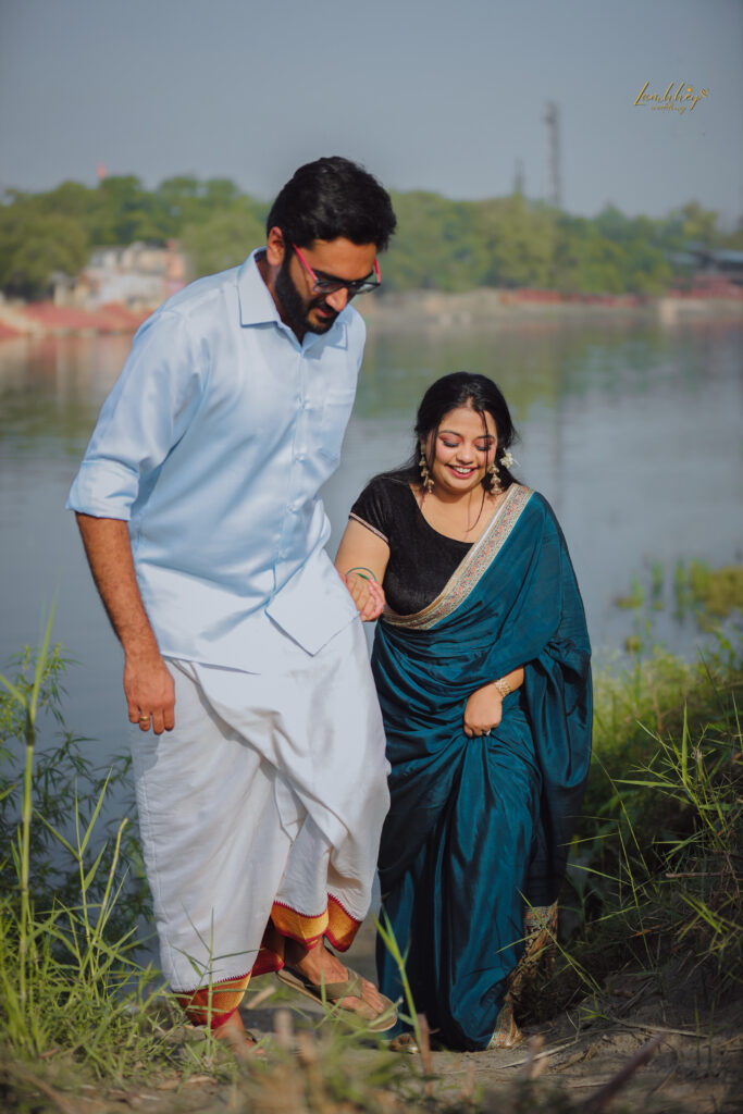 Boy in a white dhoti and a girl in a blue saree holding hands