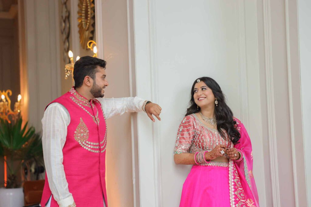 bride and groom in pink smiling at each other