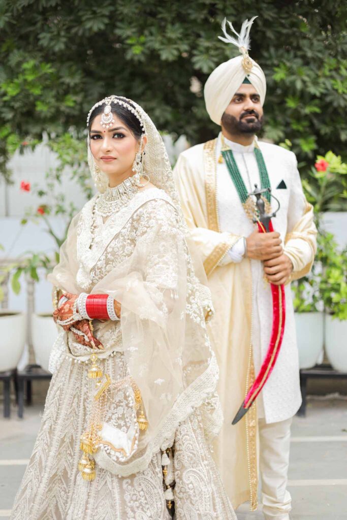 Punjabi bride in cream lehnga and groom in cream shervani