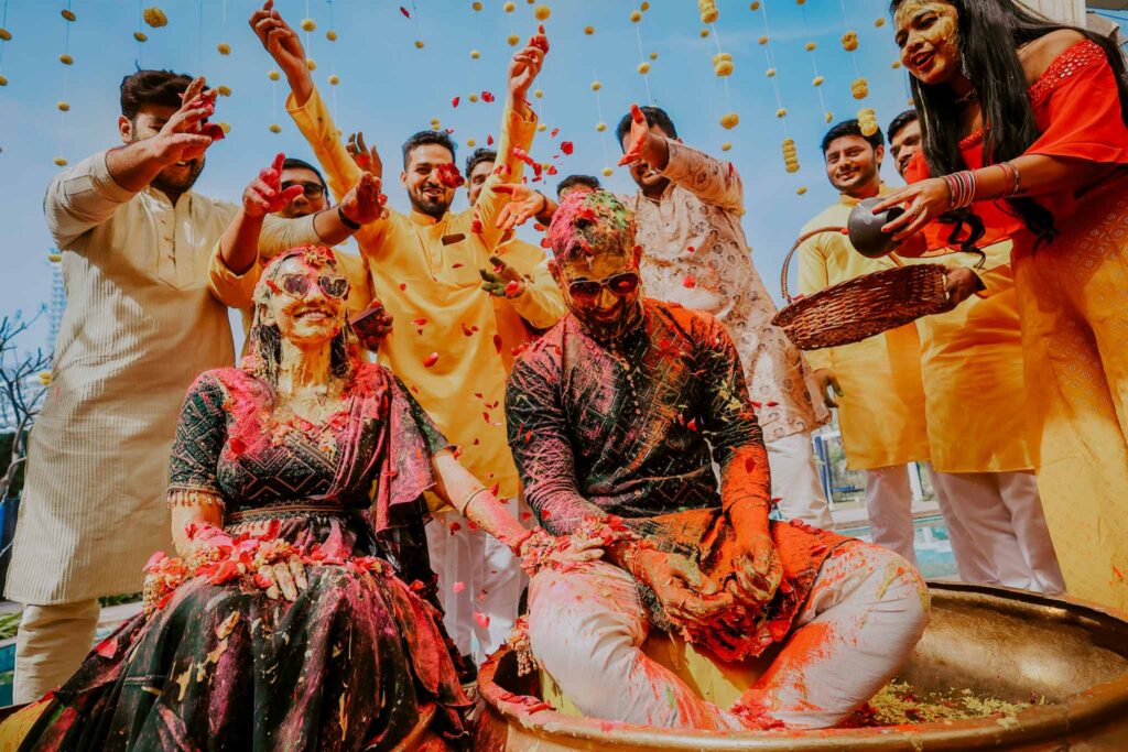 bride and groom having fun in their haldi with friends