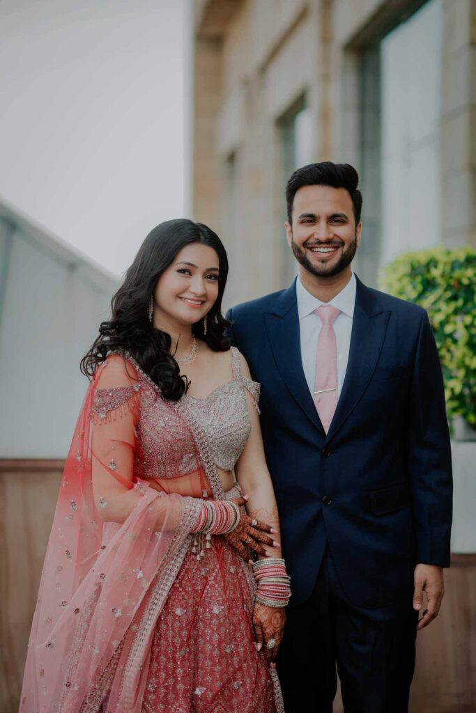 Smiling bride in pink lehnga with her groom