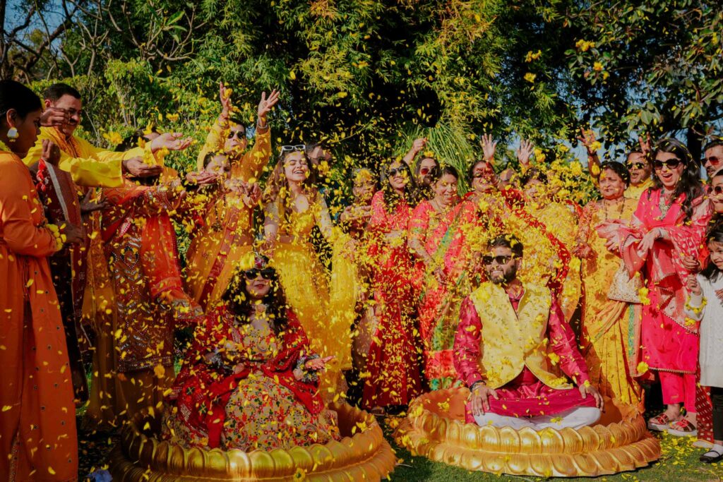 groom and bride having fun with their families in haldi