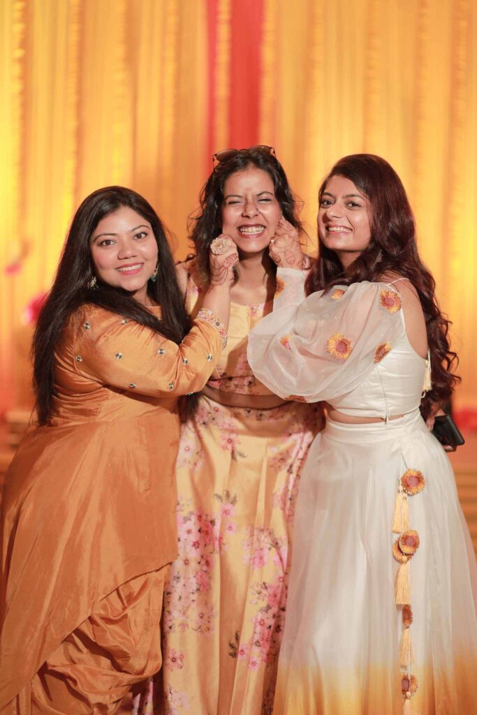 Happy bride in yellow lehnga with her sisters