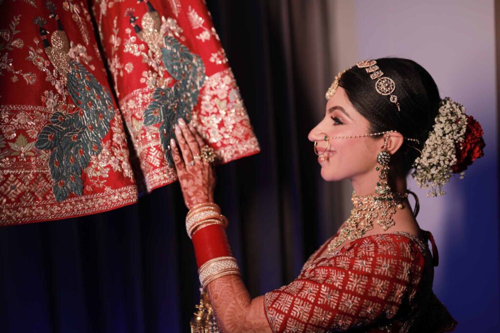 Happy bride posing with her red lehnga