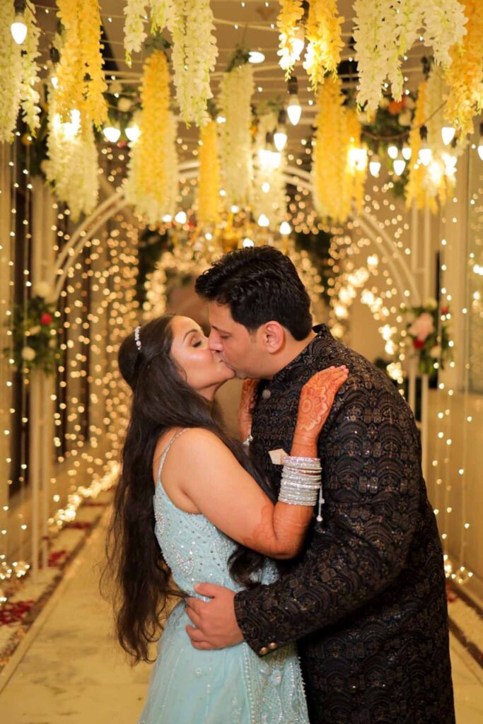 Groom in brown shervani and bride in blue lehnga having a kiss